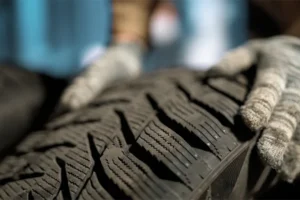 Close-up of tire tread with hands holding edge of tire