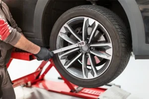 Technician removing wheel with torque wrench