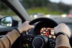 Hands holding steering wheel while driving